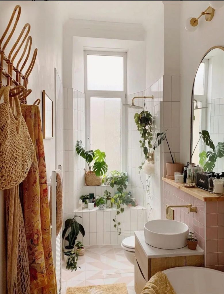 Let's talk about how to decorate the perfect boho bathroom. I noticed some common themes in the bathroom below. They feature houseplants, bamboo wood trim, and teal cabinets or tiles. Keep this in mind when looking for trends in boho bathroom design. Use natural materials and try to keep your decor as unpretentious as possible.