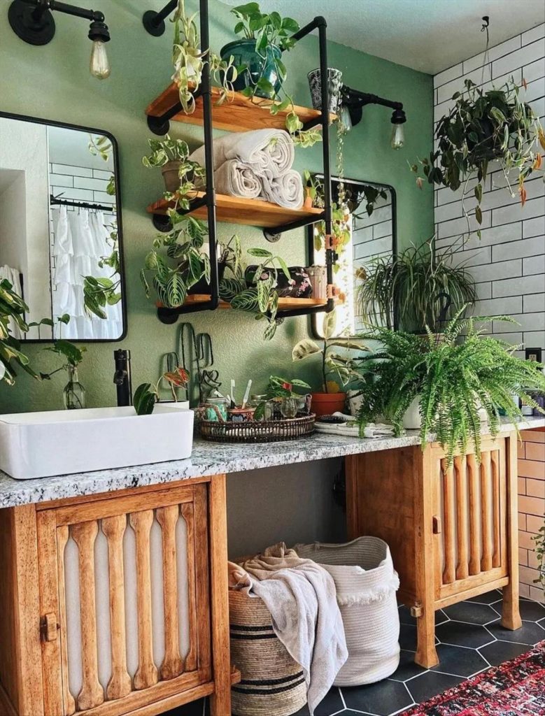 Let's talk about how to decorate the perfect boho bathroom. I noticed some common themes in the bathroom below. They feature houseplants, bamboo wood trim, and teal cabinets or tiles. Keep this in mind when looking for trends in boho bathroom design. Use natural materials and try to keep your decor as unpretentious as possible.