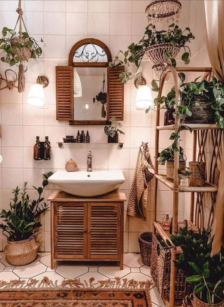 Let's talk about how to decorate the perfect boho bathroom. I noticed some common themes in the bathroom below. They feature houseplants, bamboo wood trim, and teal cabinets or tiles. Keep this in mind when looking for trends in boho bathroom design. Use natural materials and try to keep your decor as unpretentious as possible.